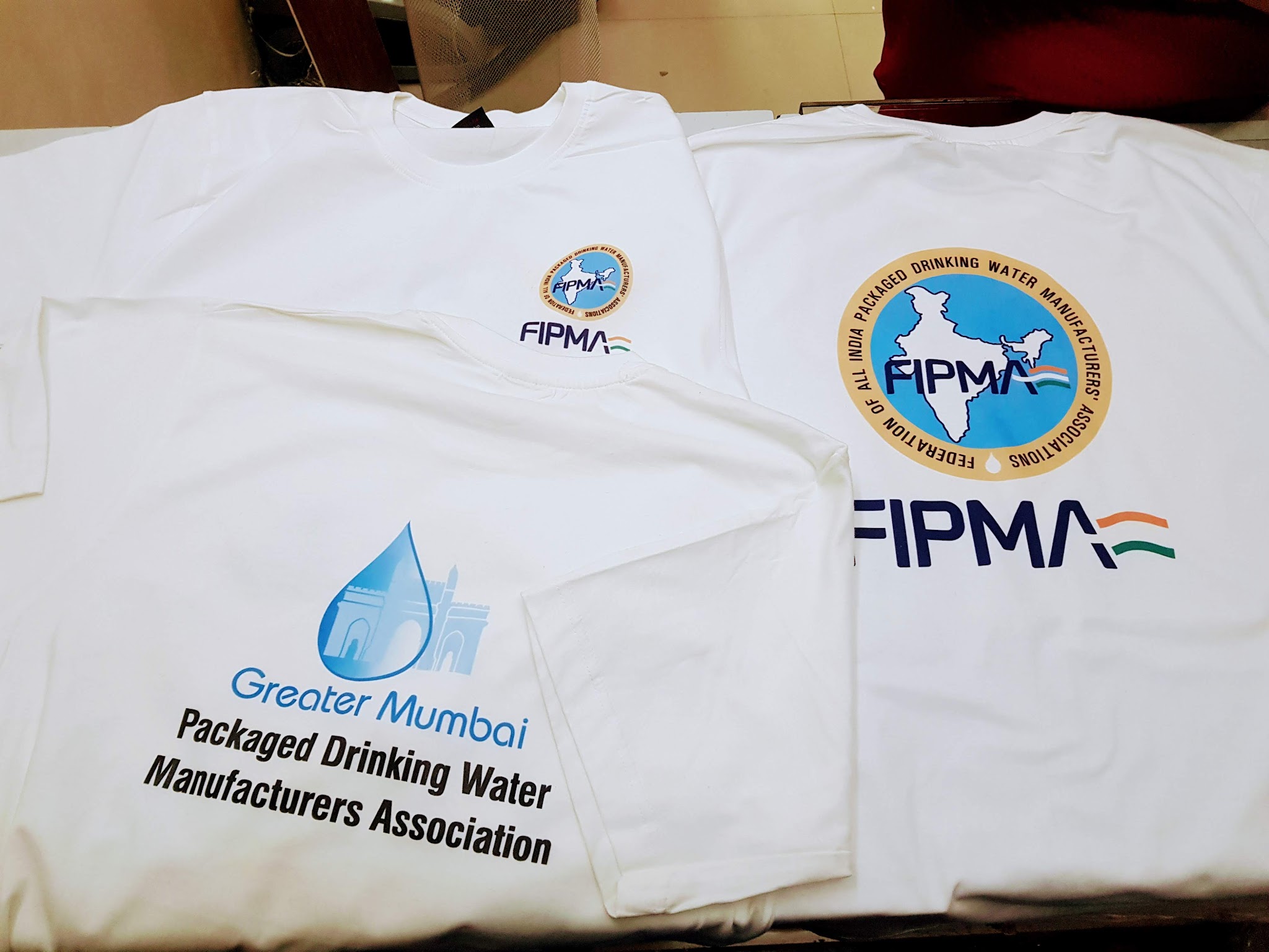 Clean white DTF printed t-shirts with corporate logo — DTF printer buying guide example output